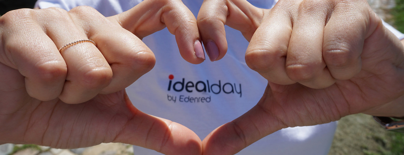 Hand forming a heart around Idealday text on t-shirt