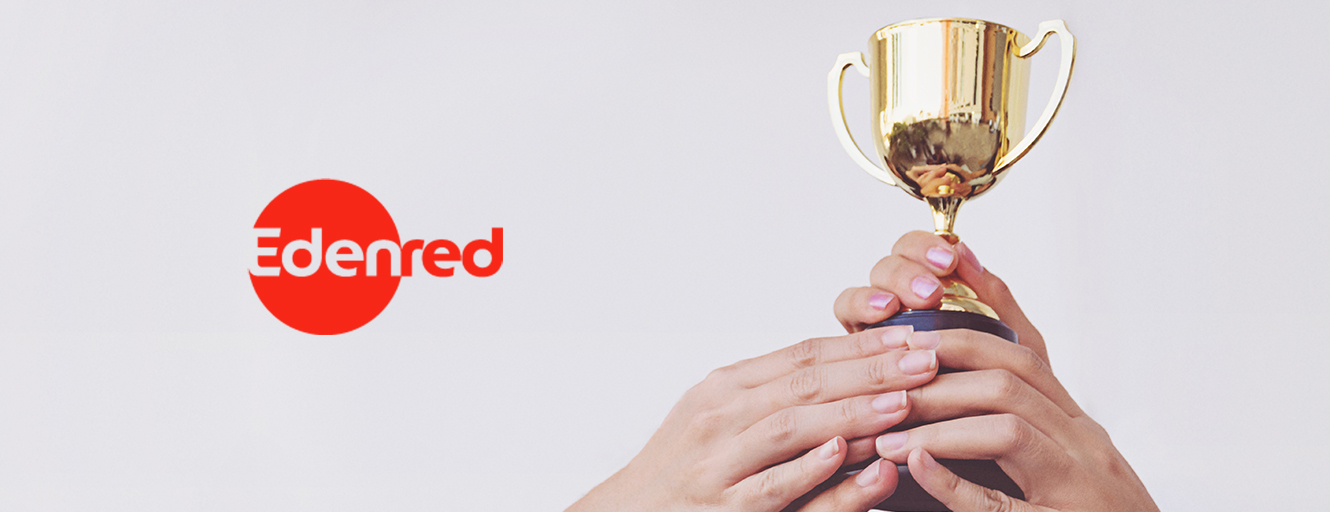 Edenred brand logo next to hands holding a trophy