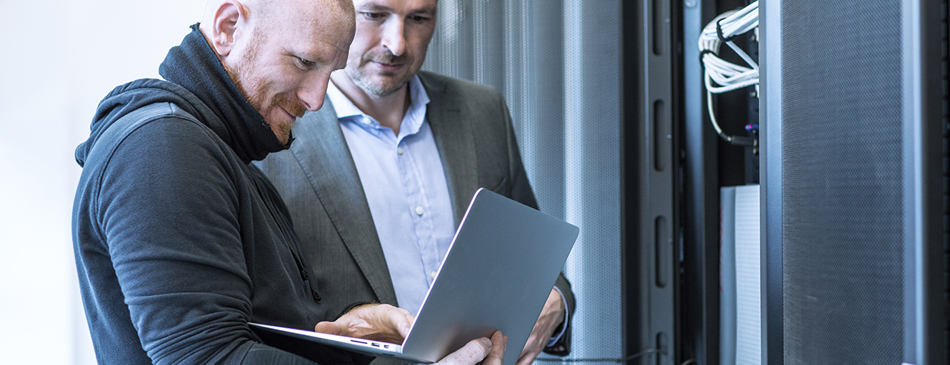 Two men using a laptop